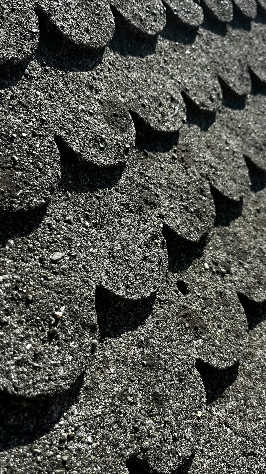 Mineral granules and black scalloped shingle edges in extreme close view